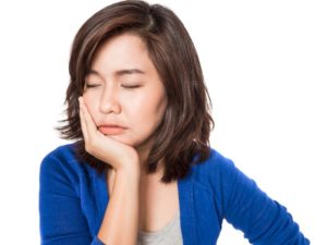 woman holding her face in pain