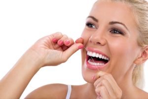 Woman flossing dental implants