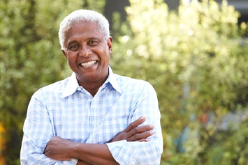 Older man with dental implants in Waco smiling outside