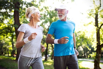 Older couple with dental implants in Waco exercising outside