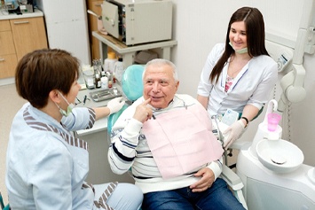Patient speaking with implant dentist in Waco and dental assistant