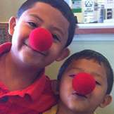 two boys wearing red ball noses