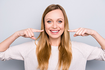 young girl pointing to white smile 