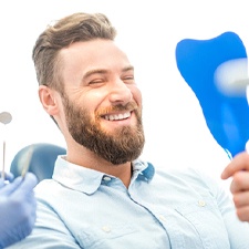 Young man admiring his new dental implants in Waco