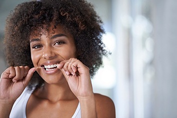 woman smiling while flossing