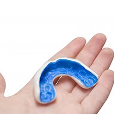 blue mouthguard in a person’s hand