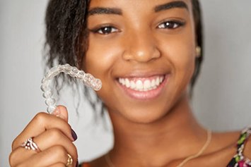 Young woman holding clear aligner