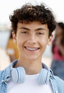 a teenager smiling with traditional braces
