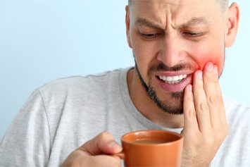 man drinking coffee with toothache 