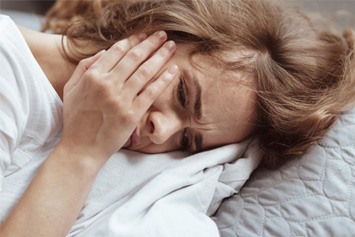 woman with toothache in bed  