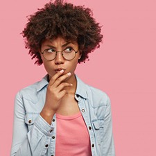 Woman tapping her chin in a questioning pose