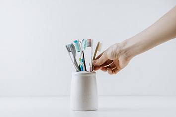 Hand reaches for toothbrush?