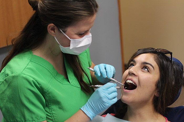 Dentist giving her patient a dental check-up