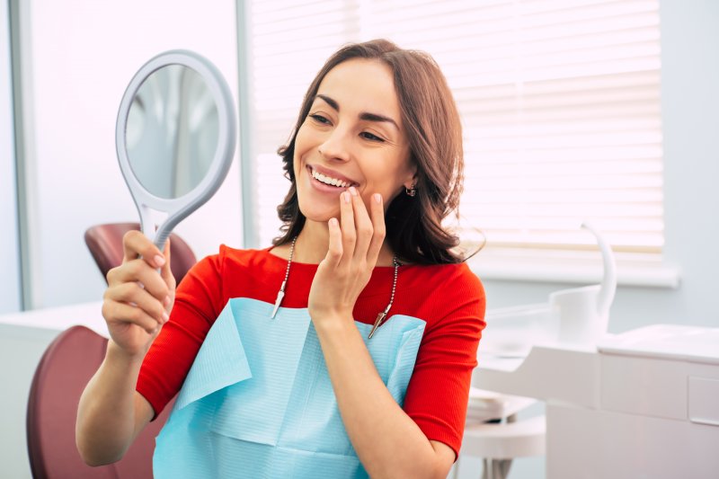 Woman looking into a mirror and smiling