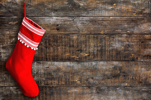 Red stocking hanging against a wooden background