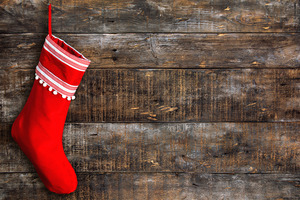 Red stocking hanging against a wooden background